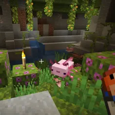 Uroczy różowy axolotl w Minecraft eksploruje jaskinię z wodospadem i kwitnącymi blokami.
